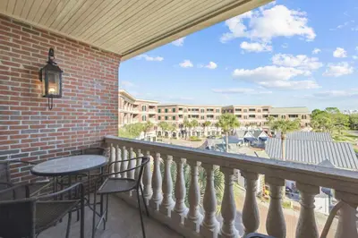 a balcony with a table and chairs and a building at Villages of South Walton B324 by 30A Escapes in Rosemary Beach