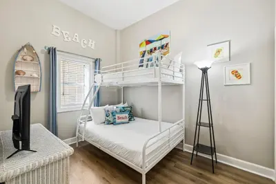 a bedroom with a white bunk bed and a television at Villages of South Walton B324 by 30A Escapes in Rosemary Beach