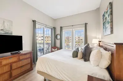 a bedroom with a bed and a flat screen tv at Villages of South Walton B324 by 30A Escapes in Rosemary Beach