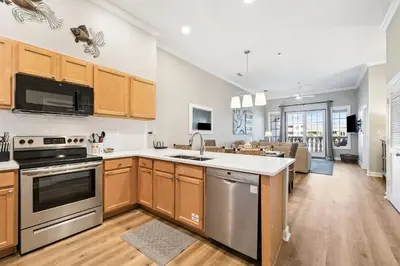 a kitchen with stainless steel appliances and wooden cabinets at Villages of South Walton B324 by 30A Escapes in Rosemary Beach