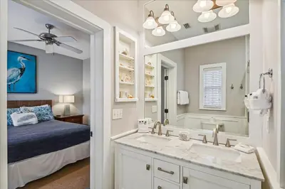 a bathroom with a bed and a sink and a mirror at Sans Souci by 30A Escapes in Seacrest