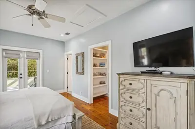 a bedroom with a flat screen tv on a dresser at Sans Souci by 30A Escapes in Seacrest