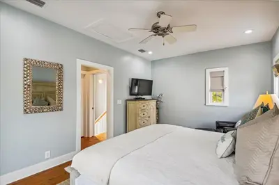 a bedroom with a white bed and a ceiling fan at Sans Souci by 30A Escapes in Seacrest