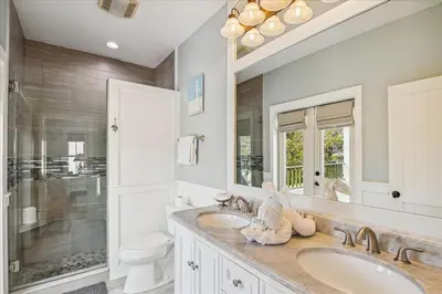 a bathroom with two sinks and a large mirror at Sans Souci by 30A Escapes in Seacrest