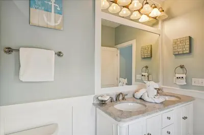 a bathroom with a sink and a large mirror at Sans Souci by 30A Escapes in Seacrest