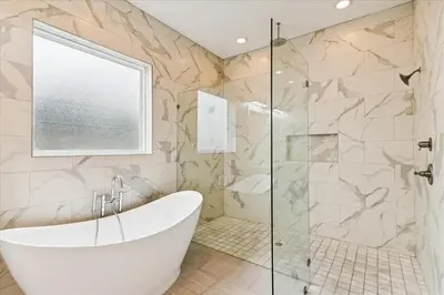 a bathroom with a tub and a glass shower at Family Tradition by 30A Escapes in Seacrest