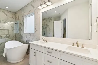 a bathroom with a tub and a sink and a mirror at Family Tradition by 30A Escapes in Seacrest