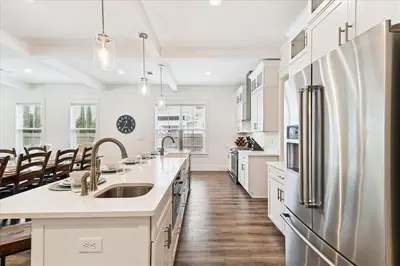a kitchen with white cabinets and a stainless steel refrigerator at Family Tradition by 30A Escapes in Seacrest