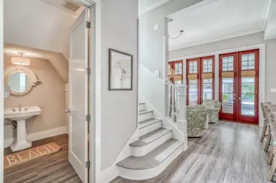 a staircase in a home with a red door at Sandy Haven by 30A Escapes in Rosemary Beach