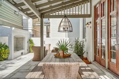 an outdoor patio with a wooden table and chairs at Sandy Haven by 30A Escapes in Rosemary Beach