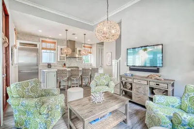 a living room with two chairs and a tv at Sandy Haven by 30A Escapes in Rosemary Beach