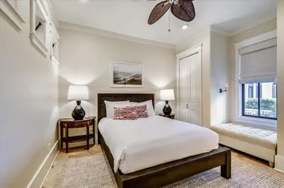 a bedroom with a bed and two lamps and a window at Pappas Cottage by 30A Escapes in Rosemary Beach