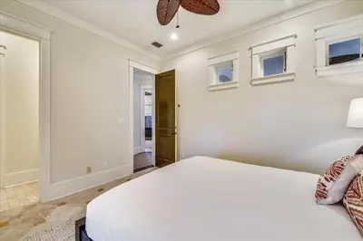 a bedroom with a white bed and windows at Pappas Cottage by 30A Escapes in Rosemary Beach
