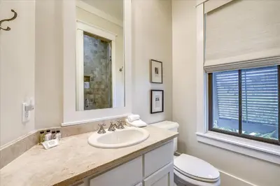 a bathroom with a sink and a toilet and a mirror at Pappas Cottage by 30A Escapes in Rosemary Beach