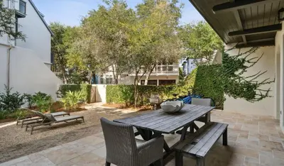 a wooden table and chairs on a patio at Pappas Cottage by 30A Escapes in Rosemary Beach