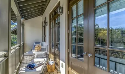 a porch with chairs and a door with windows at Pappas Cottage by 30A Escapes in Rosemary Beach