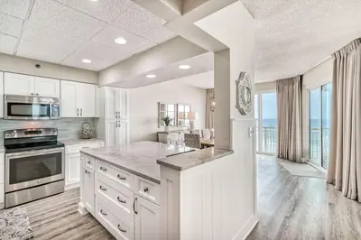 a kitchen with white cabinets and a large counter top at HP 36W Condo by 30A Escapes in Rosemary Beach