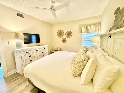 a bedroom with a white bed and a television at HP 36W Condo by 30A Escapes in Rosemary Beach