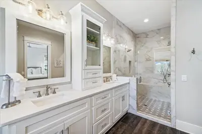 a white bathroom with two sinks and a shower at At Ease by 30A Escapes in Rosemary Beach
