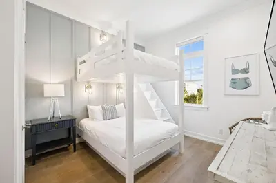 a white bunk bed in a white room with a window at Sea Castle by 30A Escapes in Sunnyside
