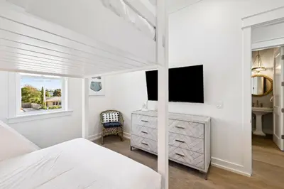 a bedroom with a bed and a dresser and a television at Sea Castle by 30A Escapes in Sunnyside