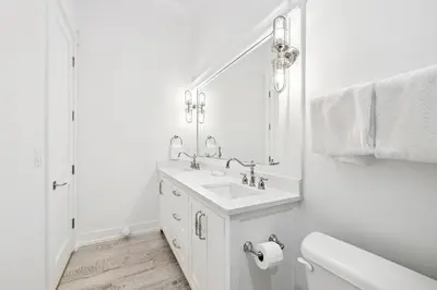 a white bathroom with a sink and a mirror at Sea Castle by 30A Escapes in Sunnyside