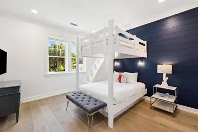a bedroom with a white bunk bed and a chair at Sea Castle by 30A Escapes in Sunnyside
