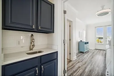 a kitchen with blue cabinets and a sink at Walkin on Sunshine by 30A Escapes in Rosemary Beach