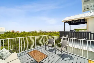 a balcony with two chairs and a table and a gazebo at Walkin on Sunshine by 30A Escapes in Rosemary Beach