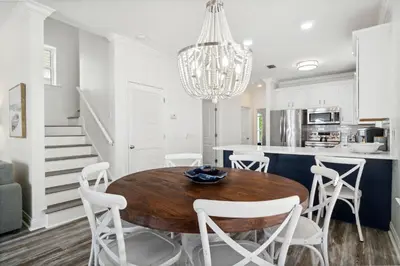 a kitchen and dining room with a wooden table and chairs at Walkin on Sunshine by 30A Escapes in Rosemary Beach