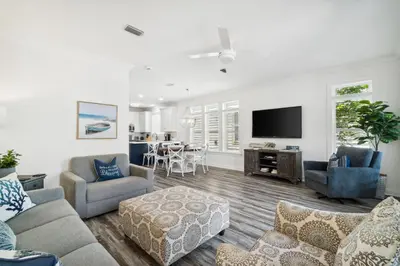 a living room with a couch and a tv at Walkin on Sunshine by 30A Escapes in Rosemary Beach