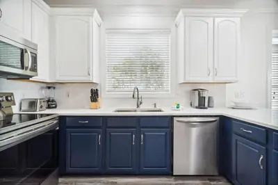 a kitchen with blue cabinets and a sink at Walkin on Sunshine by 30A Escapes in Rosemary Beach
