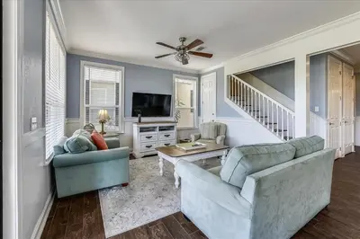 a living room with two couches and a tv at Emerald Escape by 30A Escapes in Rosemary Beach
