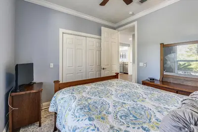 a bedroom with a bed and a flat screen tv at Emerald Escape by 30A Escapes in Rosemary Beach