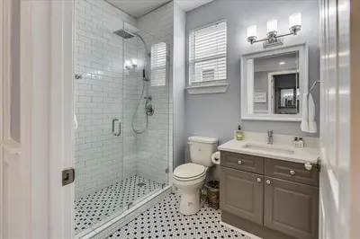 a bathroom with a toilet and a sink and a shower at Emerald Escape by 30A Escapes in Rosemary Beach
