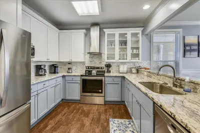 a large kitchen with white cabinets and a sink at Emerald Escape by 30A Escapes in Rosemary Beach