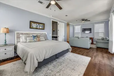 a bedroom with a large bed and a living room at Emerald Escape by 30A Escapes in Rosemary Beach