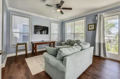 a living room with a couch and a ceiling fan at Emerald Escape by 30A Escapes in Rosemary Beach