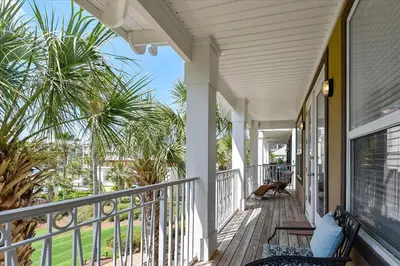 a porch of a house with palm trees at Emerald Escape by 30A Escapes in Rosemary Beach