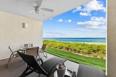a patio with a table and chairs and the ocean at HP 15E Gulf Front Condo by 30A Escapes in Rosemary Beach