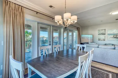 a dining room with a table and chairs and a couch at Happy Place by 30A Escapes in Rosemary Beach