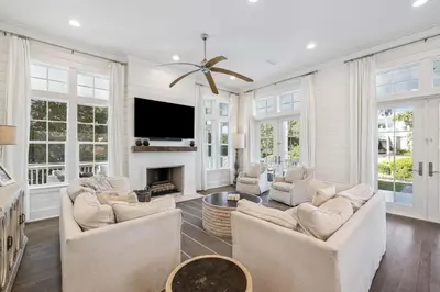 a living room with white furniture and a flat screen tv at Tidey Whitey by 30A Escapes in Seacrest