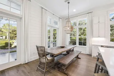 a dining room with a wooden table and chairs at Tidey Whitey by 30A Escapes in Seacrest