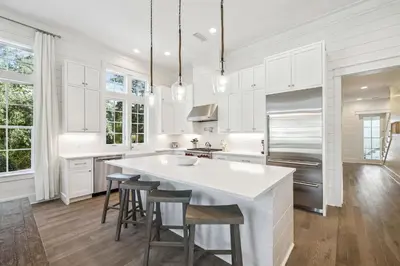 a kitchen with white cabinets and a large white island at Tidey Whitey by 30A Escapes in Seacrest