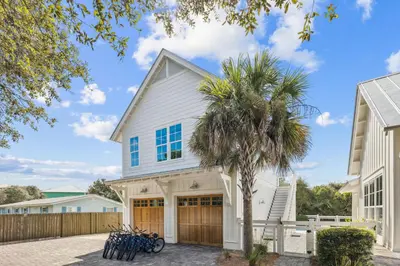 a house with a palm tree in front of it at Tidey Whitey by 30A Escapes in Seacrest