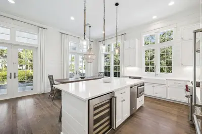 a kitchen with white cabinets and a large island at Tidey Whitey by 30A Escapes in Seacrest