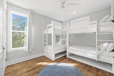 a bedroom with white bunk beds and a window at Sand Pointe by 30A Escapes in Inlet Beach