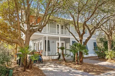 a white house with trees in front of it at Sand Pointe by 30A Escapes in Inlet Beach