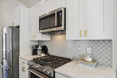 a kitchen with a stove and a microwave at Sea Ya Soon by 30A Escapes in Rosemary Beach