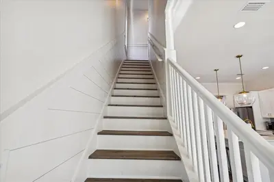 a staircase in a house with white walls at Sea Ya Soon by 30A Escapes in Rosemary Beach